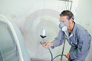Man respraying car panel