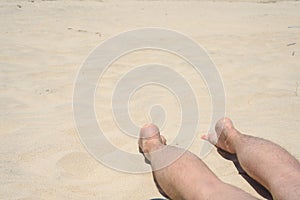 Man, rest, beach, man`s legs lie on the beach, concept rest