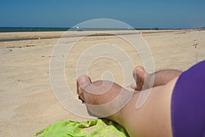 Man, rest, beach, man`s legs lie on the beach, concept rest