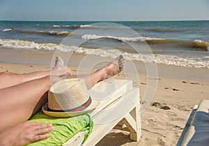 Man, rest, beach, man`s legs lie on the beach, concept rest