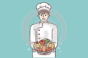 Man restaurant chef holds plate with fresh vegetables offering to make vegetable salad. Vector image