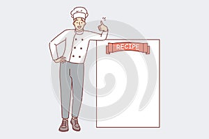 Man restaurant chef stands near blank recipe sheet and shows thumbs up as sign of approval of menu