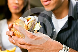 Man in a restaurant eating hamburger