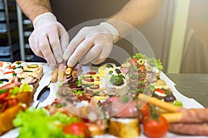 Man at restaurant putting fresh bruschetti canape finger food snacks on plate