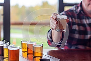 Man at a restaurant sampling beer from a beer flight