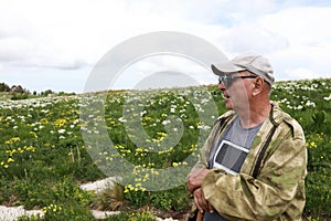 Man resting on alpine meadow of Lago-Naki plateau