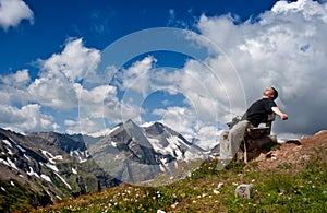 Man resting on a bench and looking at the sky.