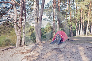 Man resting on the campsite reading a book