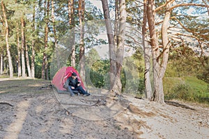 Man resting on the campsite reading a book