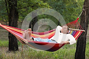 Man resting in comfortable hammock at green garden