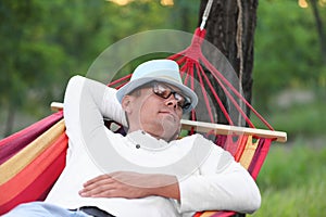 Man resting in comfortable hammock at green garden