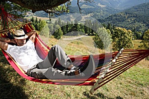 Man resting in hammock outdoors on sunny day