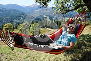 Man resting in hammock outdoors on sunny day