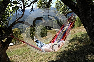 Man resting in hammock outdoors on sunny day