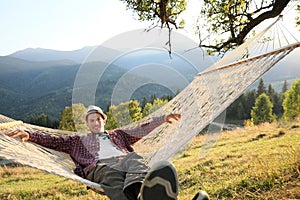 Man resting in hammock outdoors on sunny day