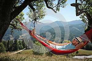 Man resting in hammock outdoors on sunny day