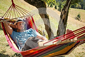 Man resting in hammock outdoors on sunny day