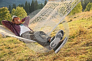 Man resting in hammock outdoors on sunny day