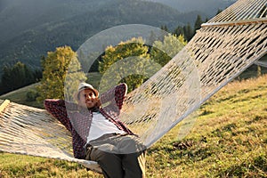 Man resting in hammock outdoors on sunny day