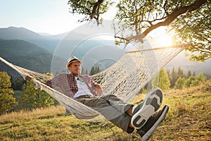 Man resting in hammock outdoors at sunset