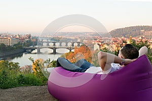 Man resting in an inflatable sofa at sunrise
