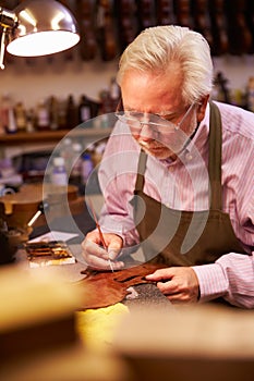 Man Restoring Violin In Workshop