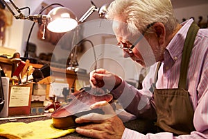 Man Restoring Violin In Workshop