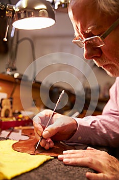 Man Restoring Violin In Workshop