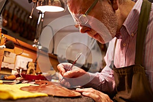 Man Restoring Violin In Workshop