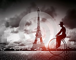 Man on retro bicycle next to Effel Tower, Paris, France.