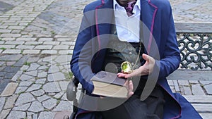 Man in retro suit at bench looking time on his pocketwatch