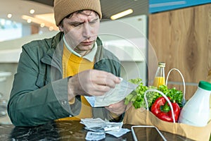 Man Reviewing Receipts with Groceries on Table photo