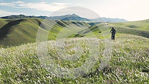 Man ride mountain bike at the green hill in the mountain of Kazakhstan