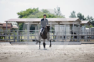 Man rider and black stallion horse galloping during equestrian dressage competition