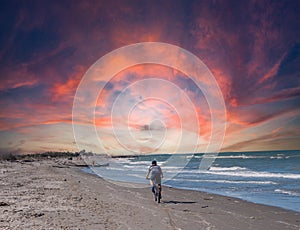 man rides a bicycle on the beach at sunset