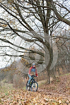 Man rides a bicycle on nature at high speed in autumn