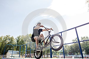 Man rides bike onback wheel of BMX. male rider makes tricks on BMX bike