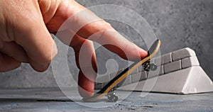 A man rides a fingerboard, practicing skills to perform a trick Pop Shiv It