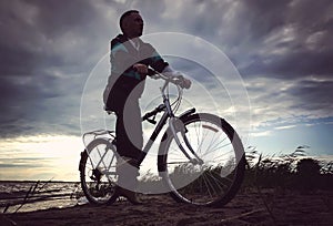 A man rides his mountain bike on a beach