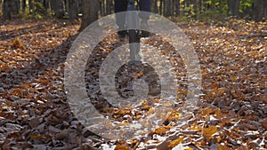 A man rides a mountain bike through dry leaves in the woods in slow motion. A guy pedaling his bicycle on a trail in an
