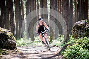A man rides a mountain bike on a forest road.