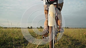 A man rides a retro bike. The man is pedaling. A cyclist rides on a field. A traveler. A fashionable bicycle. Self-isolation