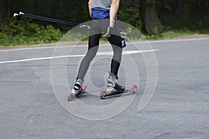 A man rides roller skis in a summer park.Cross country skiing