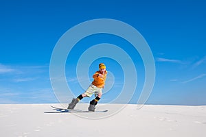 Man rides on the snowboard in desert