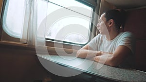 Man rides train railway looks out the window. traveler businessman concept train railroad journey travel. slow lifestyle