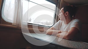 Man rides train railway looks out the window. traveler businessman concept train railroad journey travel. slow motion