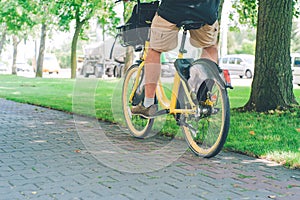 A man rides a yellow rented bike