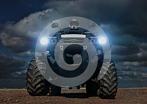 A man riding ATV in sand in protective helmet.