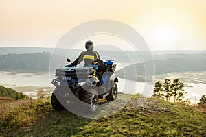 man riding atv vehicle on off road track in mountains.