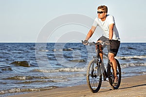 Man riding bicycle in beach photo